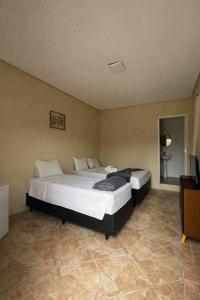 una camera da letto con due letti e una televisione di Stallage Hotel a São Pedro Altre 20 foto