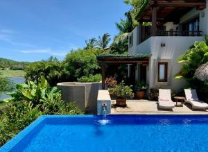 a swimming pool in front of a villa at Lagos Del Mar - Casa Dos Vistas in Punta Mita