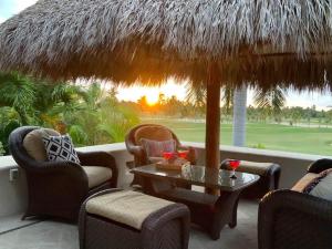 a patio with chairs and a table and a straw umbrella at Lagos Del Mar - Casa Dos Vistas in Punta Mita +16 photos