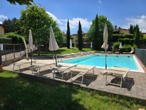 een zwembad met stoelen en parasols bij Villette di Contignano in Contignano