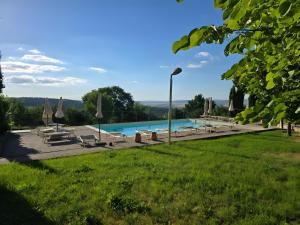 een zwembad met stoelen en parasols in een park bij Villette di Contignano in Contignano
