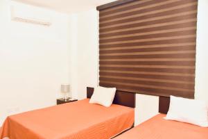 una camera da letto con due letti e una testiera in legno di Paraiso apartment 1 a Playa del Carmen Altre 22 foto