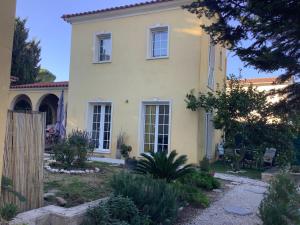 una casa gialla con una recinzione davanti di Location Studio de charme a Antibes