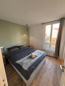 a bedroom with a large bed and a large window at Charmant T2 in Alfortville