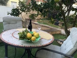 un tavolo con una bottiglia di vino e una ciotola di frutta di Location Studio de charme a Antibes