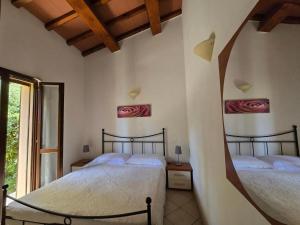 twee bedden in een kamer met een raam bij Villette di Contignano in Contignano