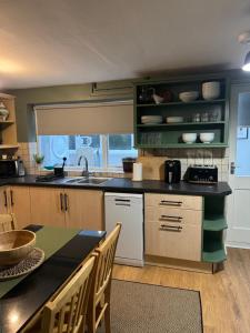 een keuken met een spoelbak en een tafel met stoelen bij Cottage in Llanberis in Llanberis