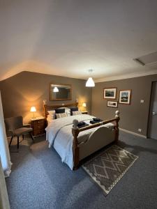 een slaapkamer met een groot bed en een stoel bij Cottage in Llanberis in Llanberis