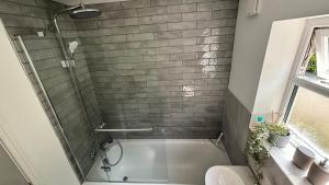 a bathroom with a shower and a bath tub at Snowdon Cottage in Llanberis