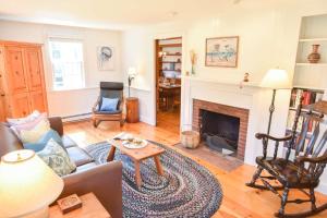 a living room with a couch and a fireplace at Walk to Water w Stunning Cove Views in Eastham