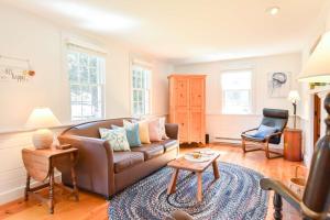 a living room with a couch and a chair at Walk to Water w Stunning Cove Views in Eastham