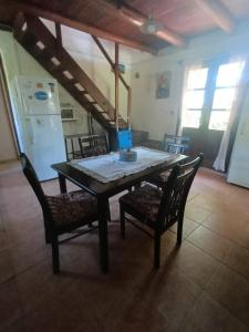 a dining room table with two chairs and a refrigerator at Casa de Amelia (Punta Rubia) in La Pedrera