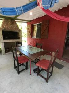 a wooden table and chairs in front of a house at Casa de Amelia (Punta Rubia) in La Pedrera