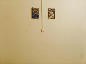 twee foto's hangen aan een witte muur bij huazhi in Accra