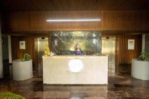 een vrouw achter een toonbank in een gebouw bij Cozy, elegant 2BR steps to US Consulate in Xcumpich +37 foto's