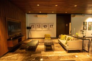 een woonkamer met een bank en een tv bij Cozy, elegant 2BR steps to US Consulate in Xcumpich