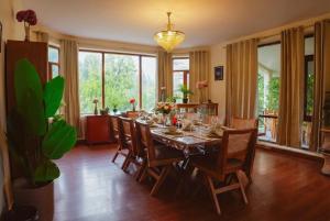 een eetkamer met een lange tafel en stoelen bij The ForestBound Cottage in Manāli