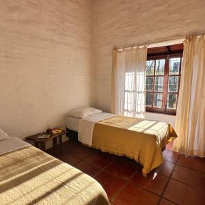 een slaapkamer met twee bedden en een raam bij Casa cercana a plaza de Villa de las Rosas con patio y asador in Villa Las Rosas