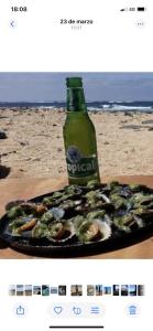 una bottiglia di birra e un piatto di cibo sulla spiaggia di Casa Doramas a San José de Caideros