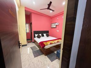 a bedroom with a bed with a pink wall at Hotel DK Inn sasaram in Sasarām