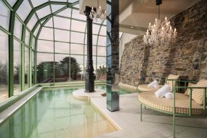 an indoor pool with chairs and a chandelier at Nuvole Garden Hotel in Brunate