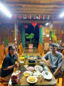 同文Experience Nature at Our Semi-Campsite in the Heart of the Mountains的两个人坐在餐桌上吃着食物