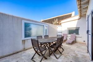 a patio with a table and chairs on a balcony at Le Boumian in Saintes-Maries-de-la-Mer