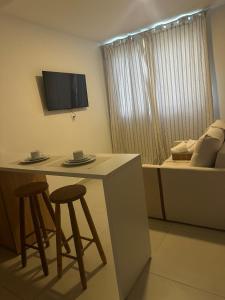 a kitchen with two stools and a table and a bed at Studio On Mateus in Juiz de Fora