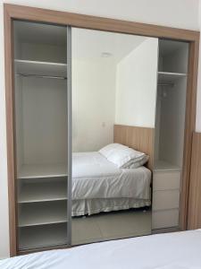 a glass closet with a bed in a bedroom at Studio On Mateus in Juiz de Fora