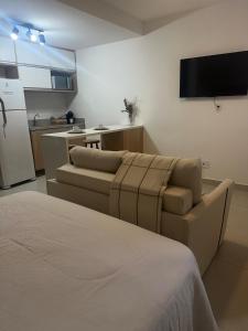 a living room with a couch and a kitchen at Studio On Mateus in Juiz de Fora