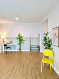 Ein leeres Zimmer mit einem gelben Stuhl und einem Schreibtisch in der Unterkunft The See Stay Hatyai in Hat Yai