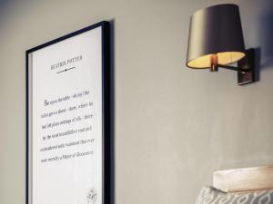 格洛斯特格洛斯特鲍顿大厦美居酒店的墙上挂着一张菜单图片，还有一盏灯