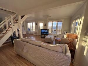 a living room with two couches and a staircase at Seaside Cottage 180 Views in Petit-Etang