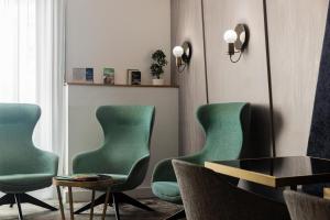 a living room with green chairs and a table at Best Western Plus Comedie Saint Roch in Montpellier