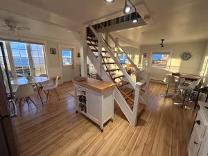 a living room with a staircase and a dining room at Seaside Cottage 180 Views in Petit-Etang