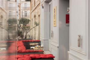 a row of red cushioned benches in a store window at Best Western Plus Comedie Saint Roch in Montpellier