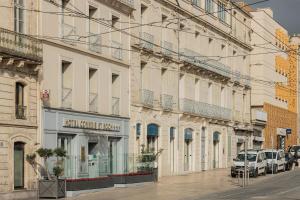 a city street with cars parked in front of buildings at Best Western Plus Comedie Saint Roch in Montpellier