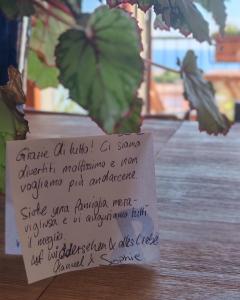 a note sitting on top of a table with a plant at B&B Mareluce in Torre del Greco