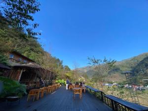eine Gruppe von Personen, die an Tischen auf einem Deck sitzen in der Unterkunft Chiba Ecolodge Mù Cang Chải in Mù Cang Chải