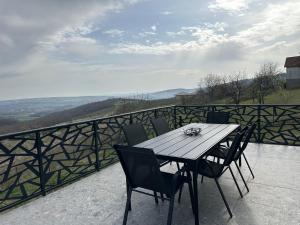 een houten tafel en stoelen op een balkon bij Wine Valley Villas in Lipovac