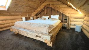 een slaapkamer met een bed in een blokhut bij Cabana de la Stână in Rîşnov