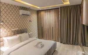 une chambre avec un grand lit blanc dans une pièce dans l'établissement Atlanticblu hotels & Resort, à Abuja