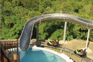 un tour de montagnes russes avec un toboggan au-dessus d'une piscine dans l'établissement Bamboo - Sleeps 6 - Garden - Parking, à Bamboo