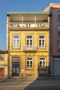 a yellow brick building with a balcony on a street at Limehome Porto Rua de Dom Manuel II in Porto