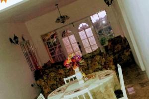 une salle à manger avec une table et des fleurs sur un canapé dans l'établissement Bamboo - Sleeps 6 - Garden - Parking, à Bamboo