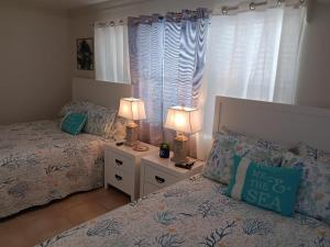 een slaapkamer met 2 bedden en 2 lampen op een nachtkastje bij Madeira Bonita in St Pete Beach