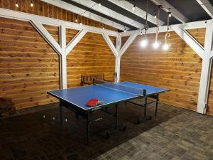 een tafeltennistafel in een kamer met houten wanden bij Dom "Między jeziorami" na Kaszubach, 10 osób, jacuzzi, ognisko, kominek in Grabówko