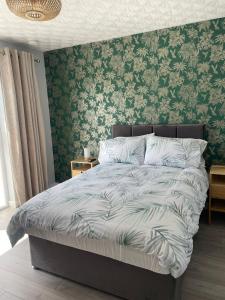een bed in een slaapkamer met groen behang bij Rest a While in Bushmills +48 foto's