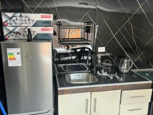 a kitchen with a sink and a refrigerator at CASA DEL CENTRo in Quellón