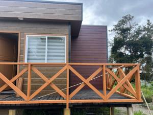 a house with a wooden deck in front of it at CASA DEL CENTRo in Quellón